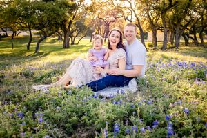 San Antonio family bathed in sunlight, posing in the iconic Texas Bluebonnets.