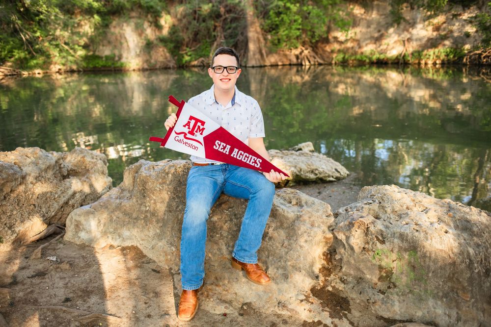 San Antonio senior graduate posing for senior portraits in front of the Guadalupe River at Cypress Bend Park in New Braunfels, Texas.