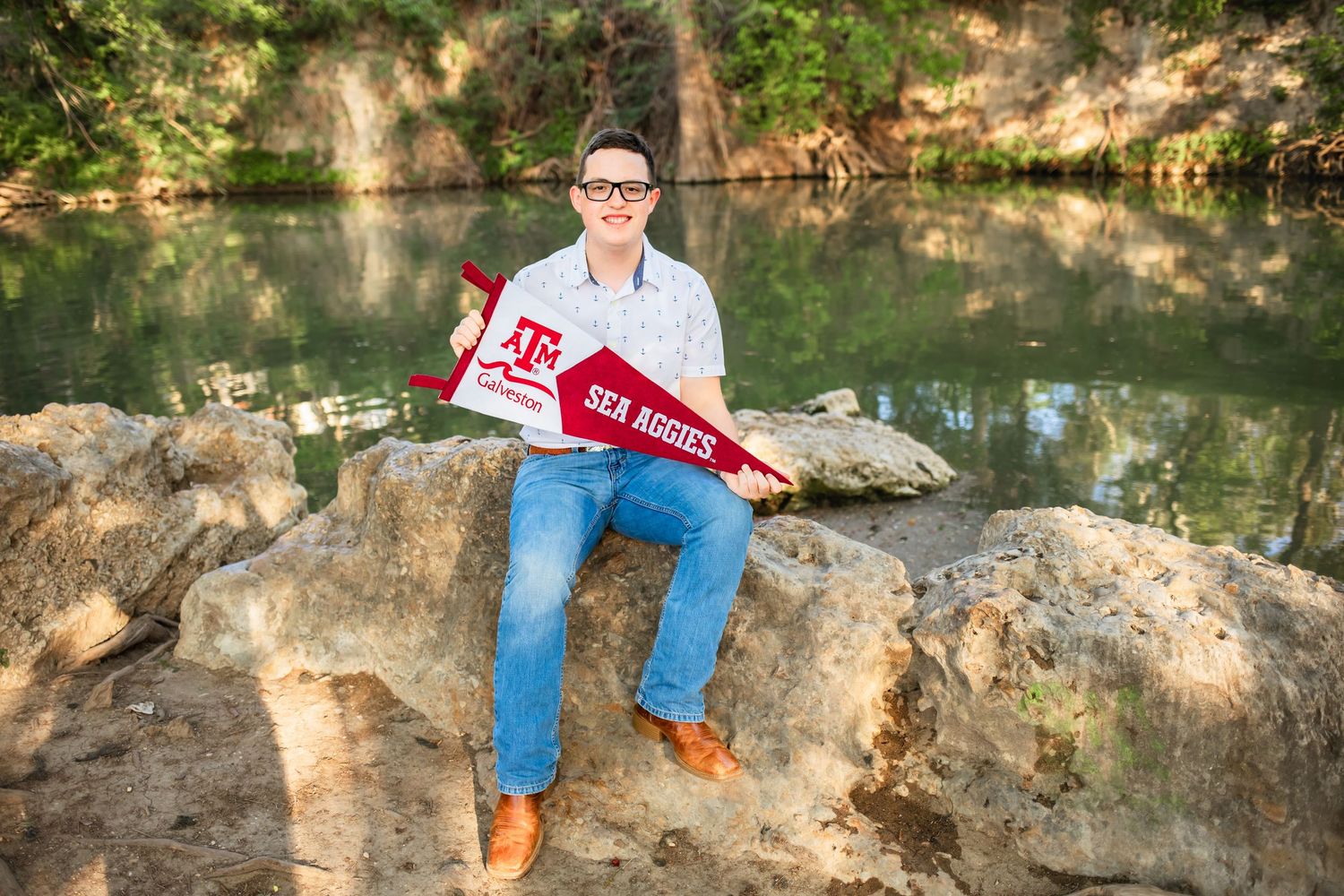 San Antonio senior graduate posing for senior portraits in front of the Guadalupe River at Cypress Bend Park in New Braunfels, Texas.