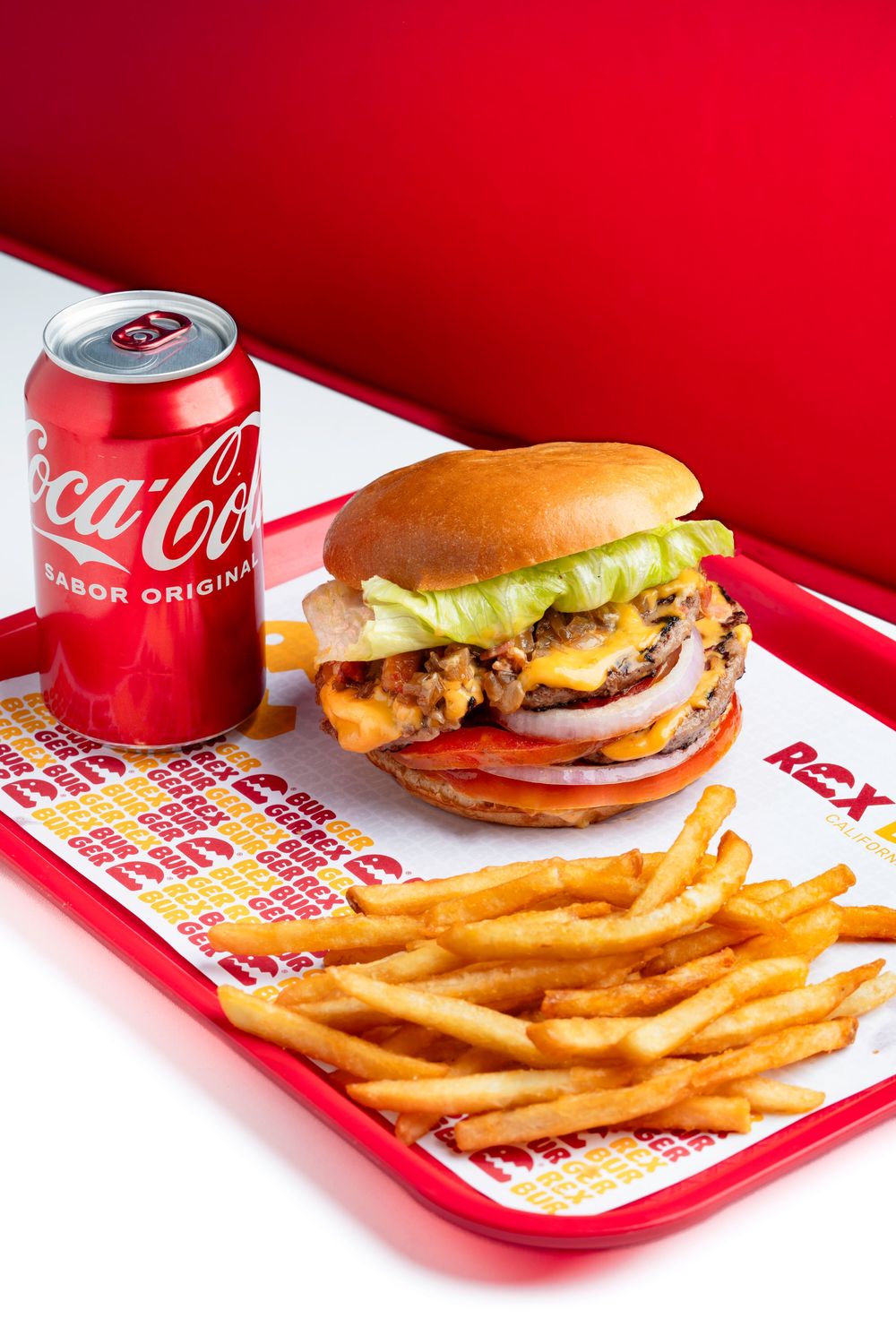 Classic fast food burger meal with fries and Coca-Cola on red tray.