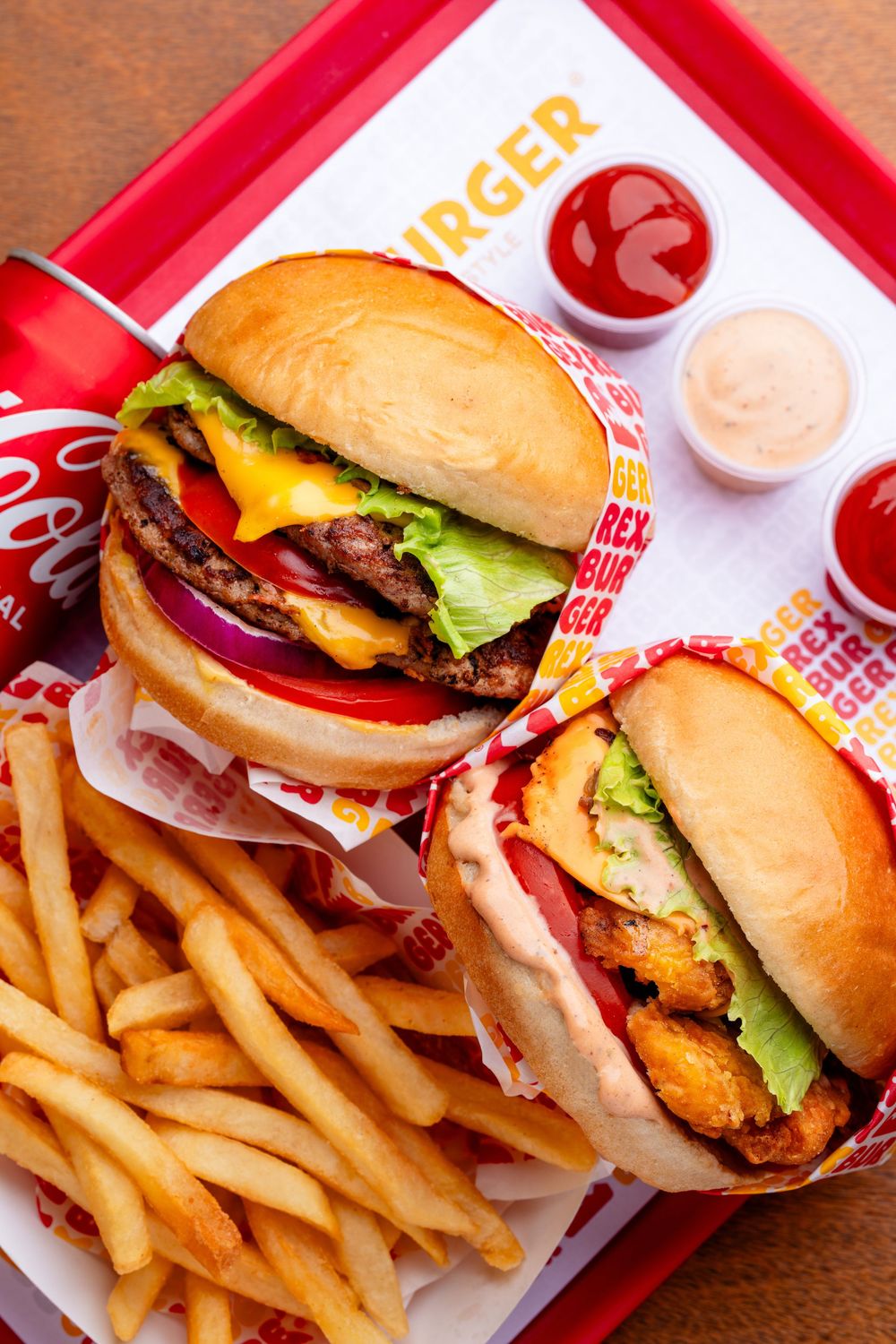 Juicy cheeseburgers with fries served on red trays at a fast food restaurant.