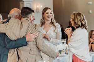 A joyful celebration with guests laughing and mingling at an indoor event.
