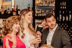 Celebratory moment captured at a bar with guests laughing and enjoying drinks.