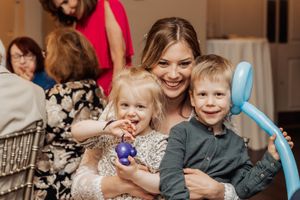 A festive gathering with balloon decorations and happy guests enjoying the celebration.