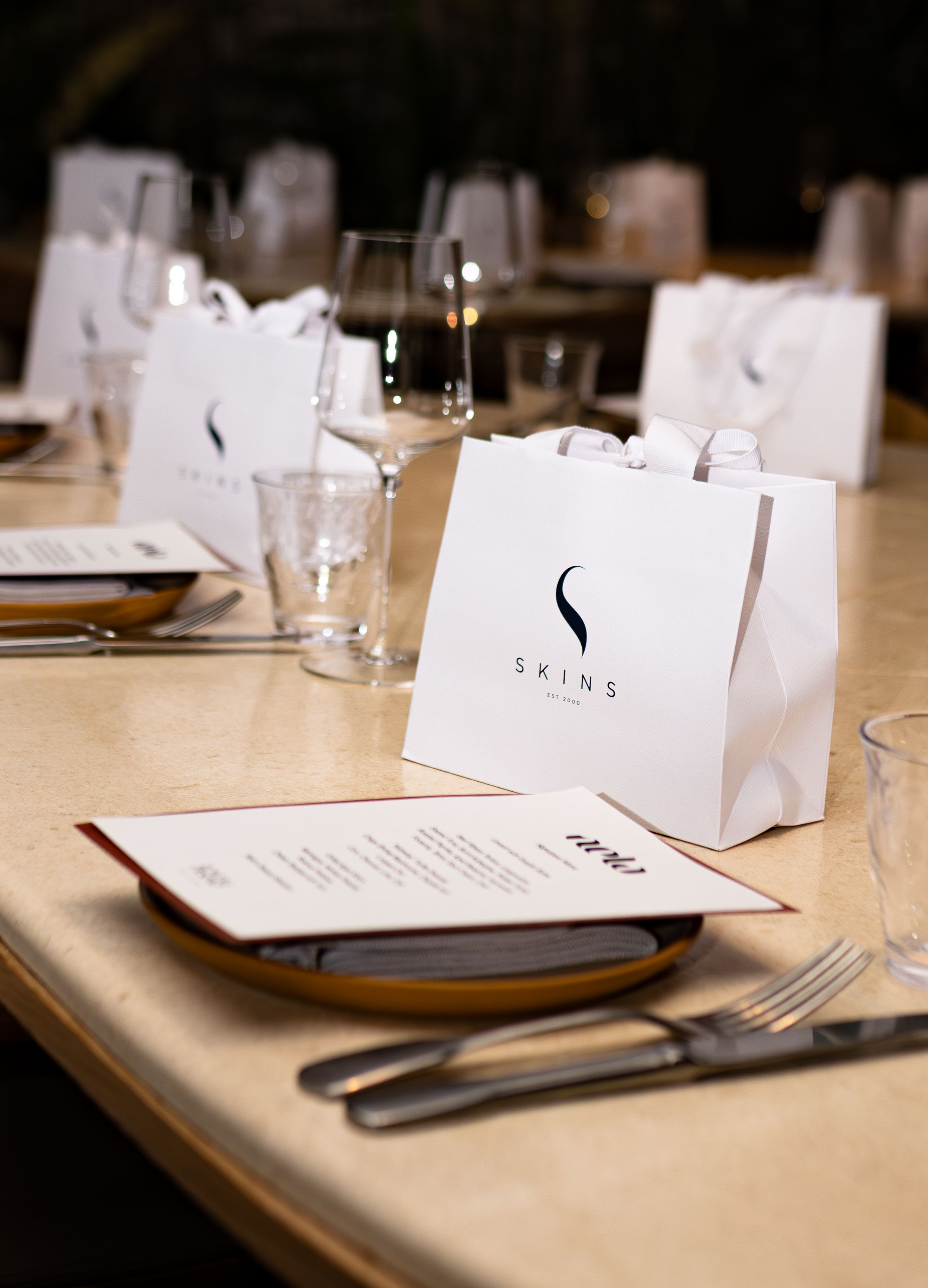 Modern restaurant table setting with white place cards and elegant dinnerware.