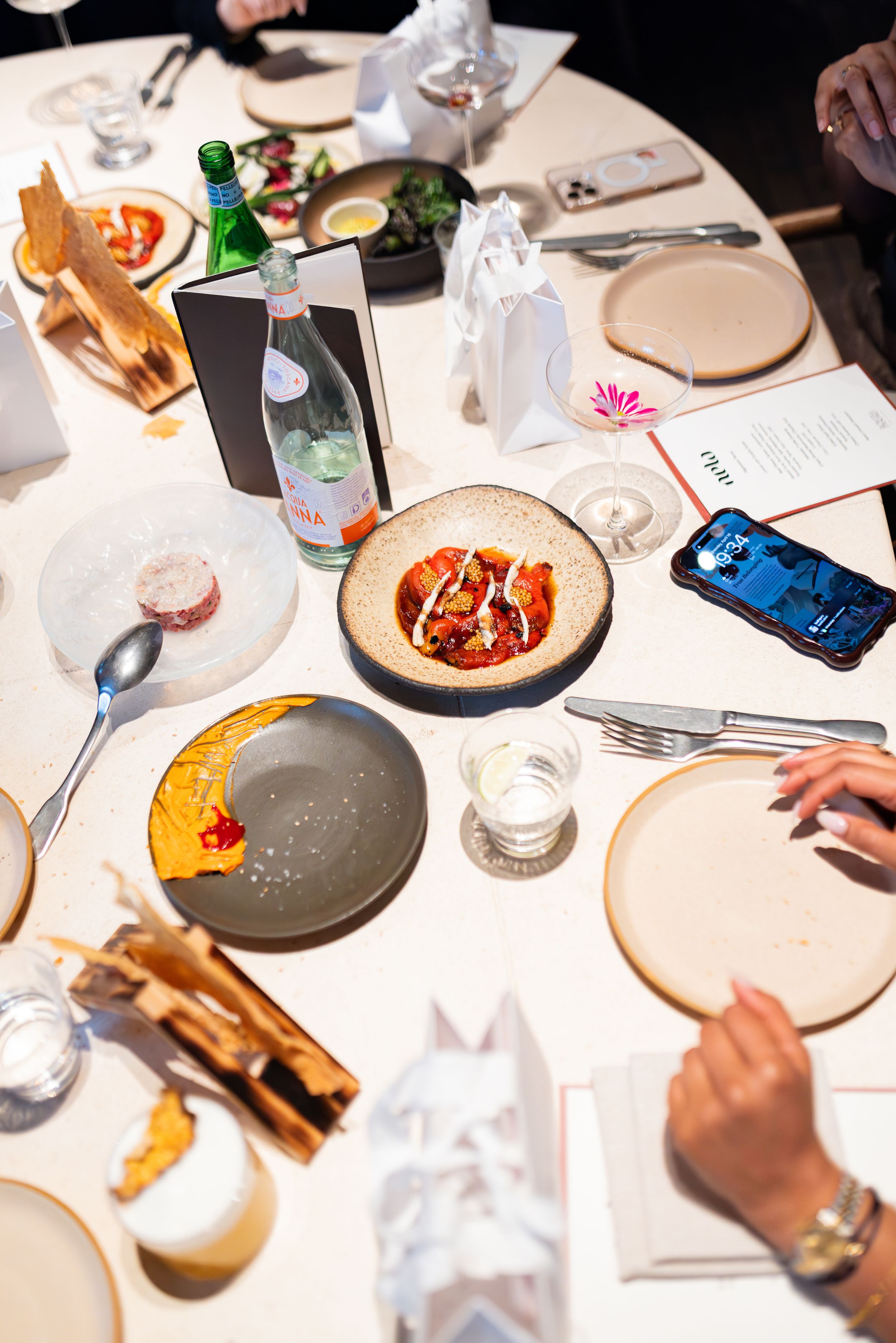 Overhead view of a dining table with plates of colorful food and drinks.