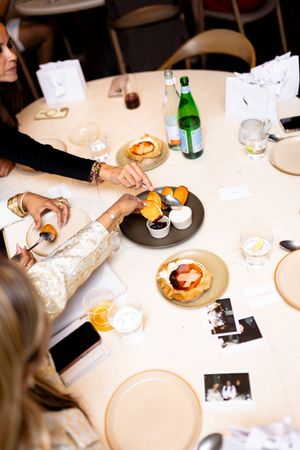 Diners enjoying food and conversation at an elegant white tablecloth restaurant.