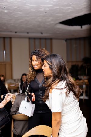 Group of friends sharing laughs and embracing at an indoor gathering.