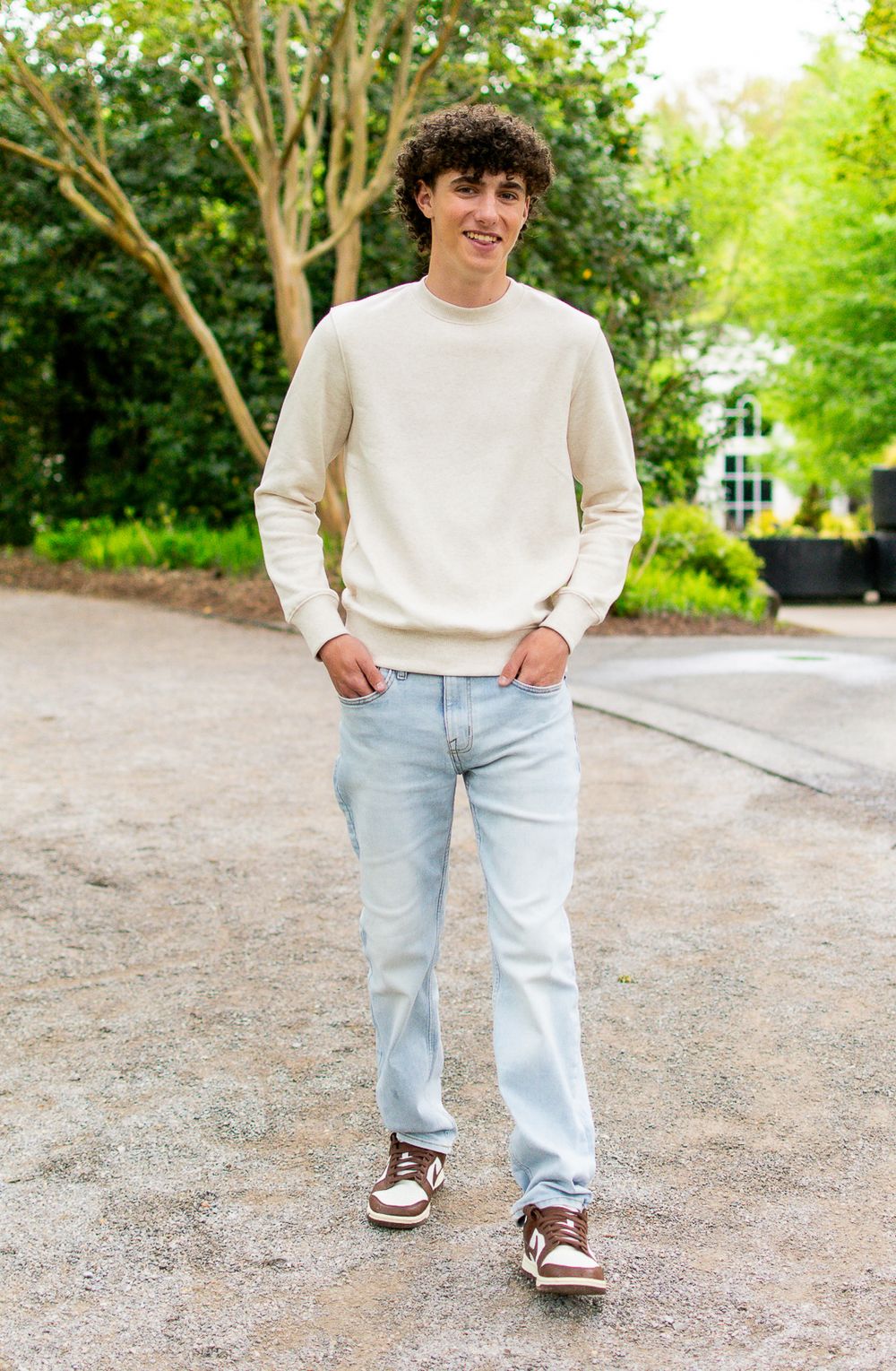 Person in light colored sweater and jeans walking on outdoor path showing casual style.