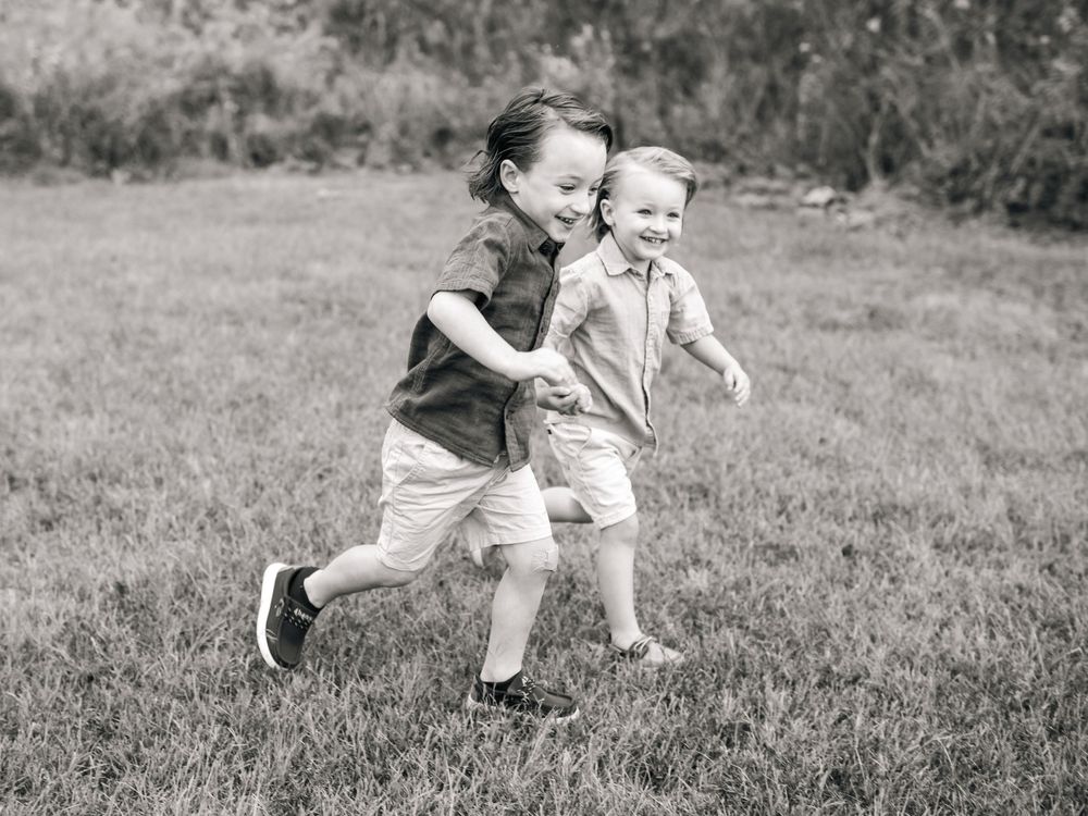 Joyful playtime captured in black and white on grassy field.