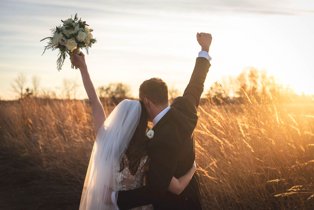 Cinematic golden hour moment with the couple in a field.