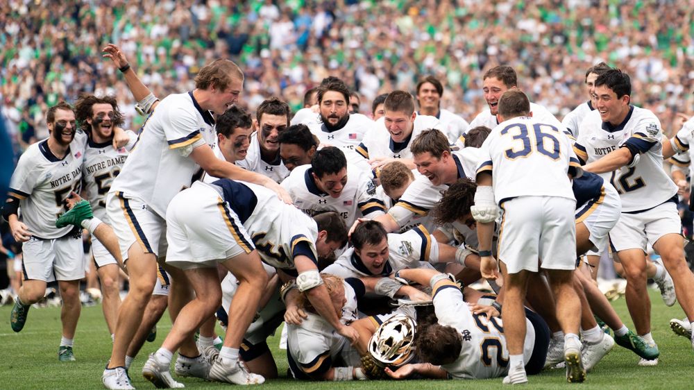 Rugby players celebrate in a huddle after scoring a try during a match.