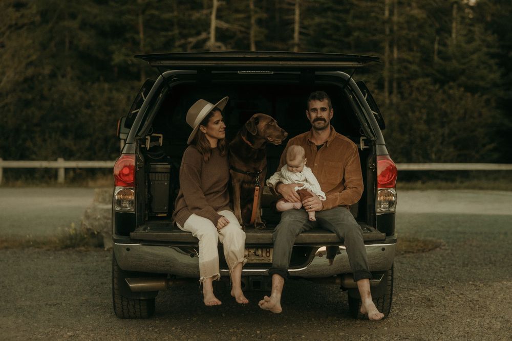 Group relaxing in back of truck during outdoor adventure.