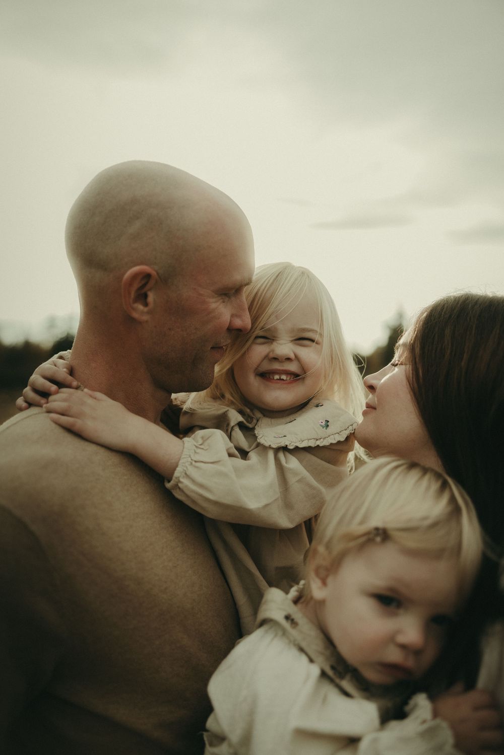 A sweet family moment shared outdoors in warm evening light.