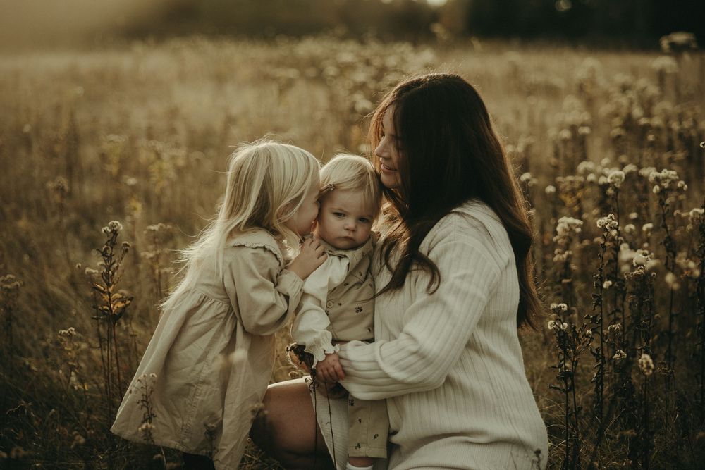 A family shares joyful moments together in a wildflower field at sunset.