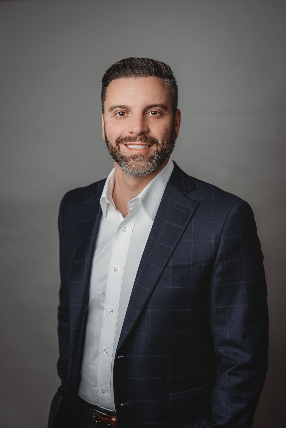 Business man posing for headshot on grey backdrop in studio headshot session in Etobicoke