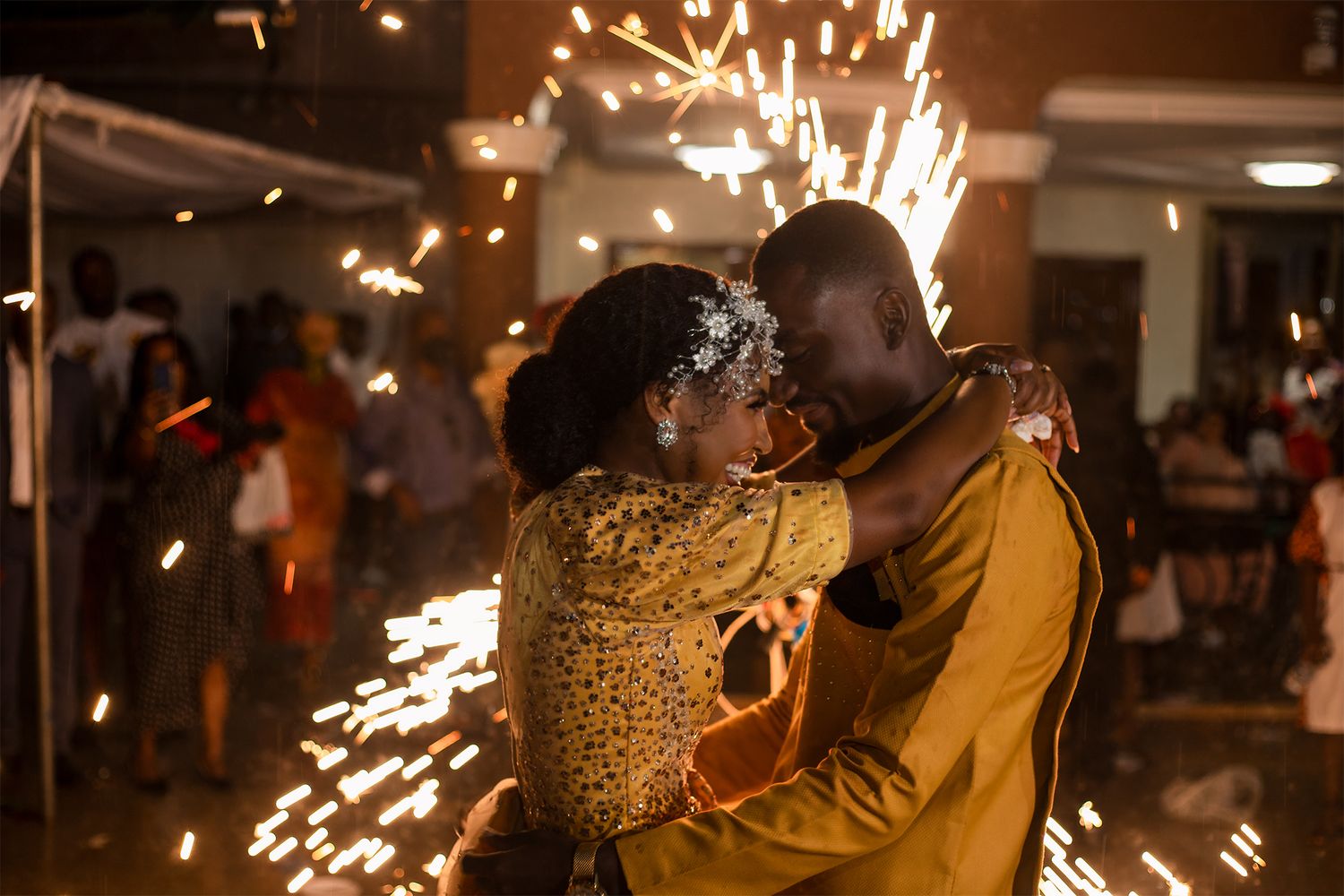 A romantic moment captured with sparklers creating a magical background effect.