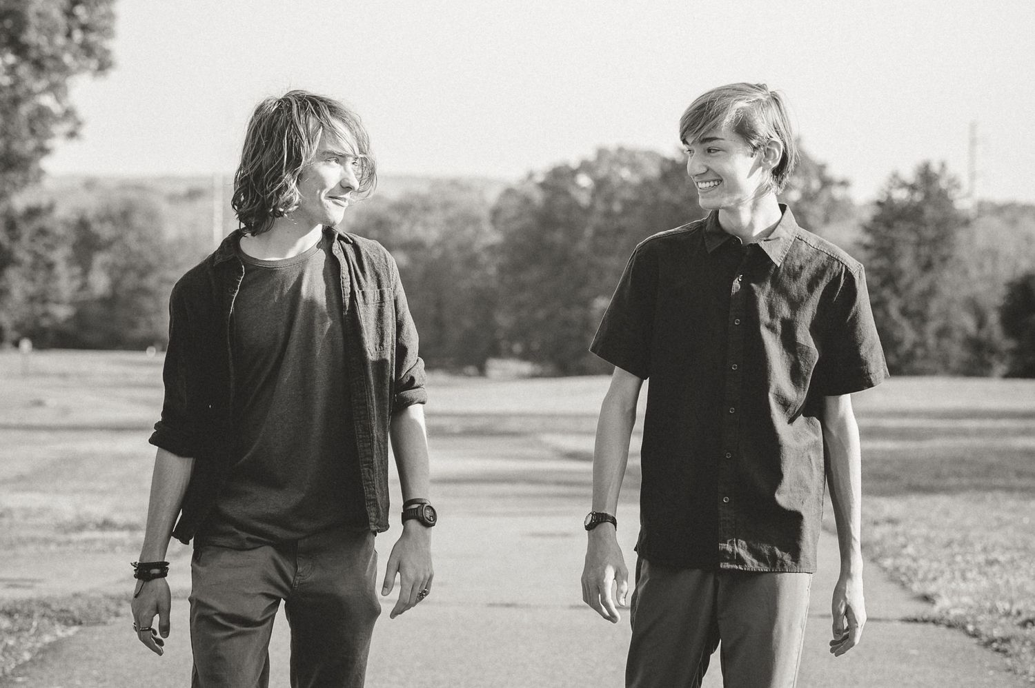 Two people walking on a path captured in black and white photography.