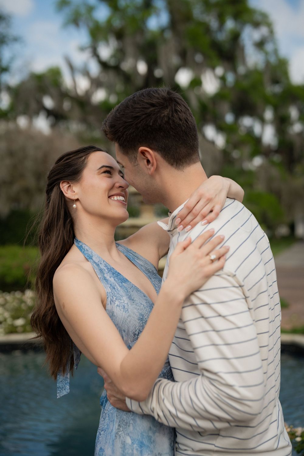 Couple cradling baby bump together during a beach maternity session