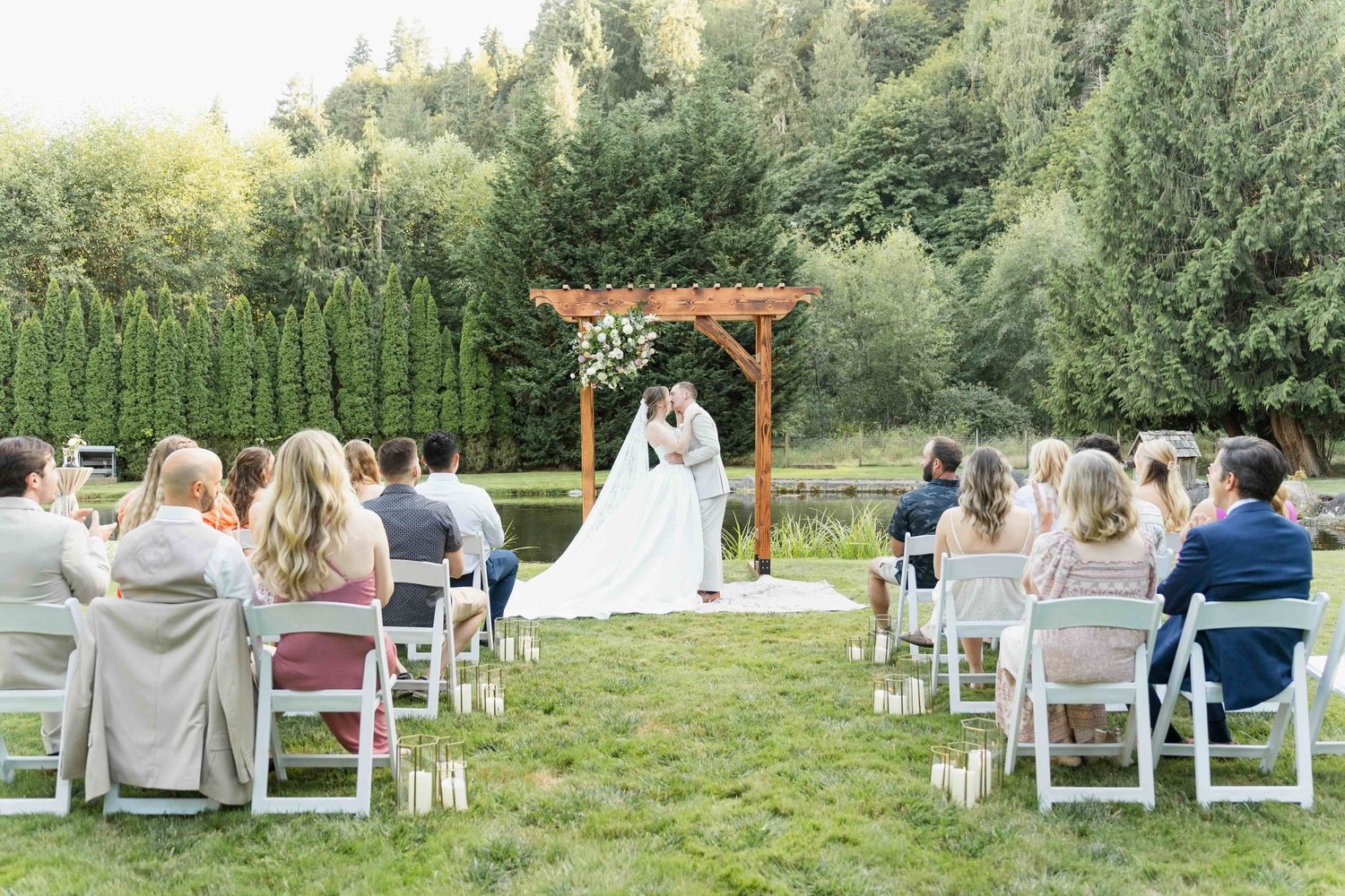 A joyful celebratory moment at an outdoor wedding ceremony with gathered guests at a brick venue.