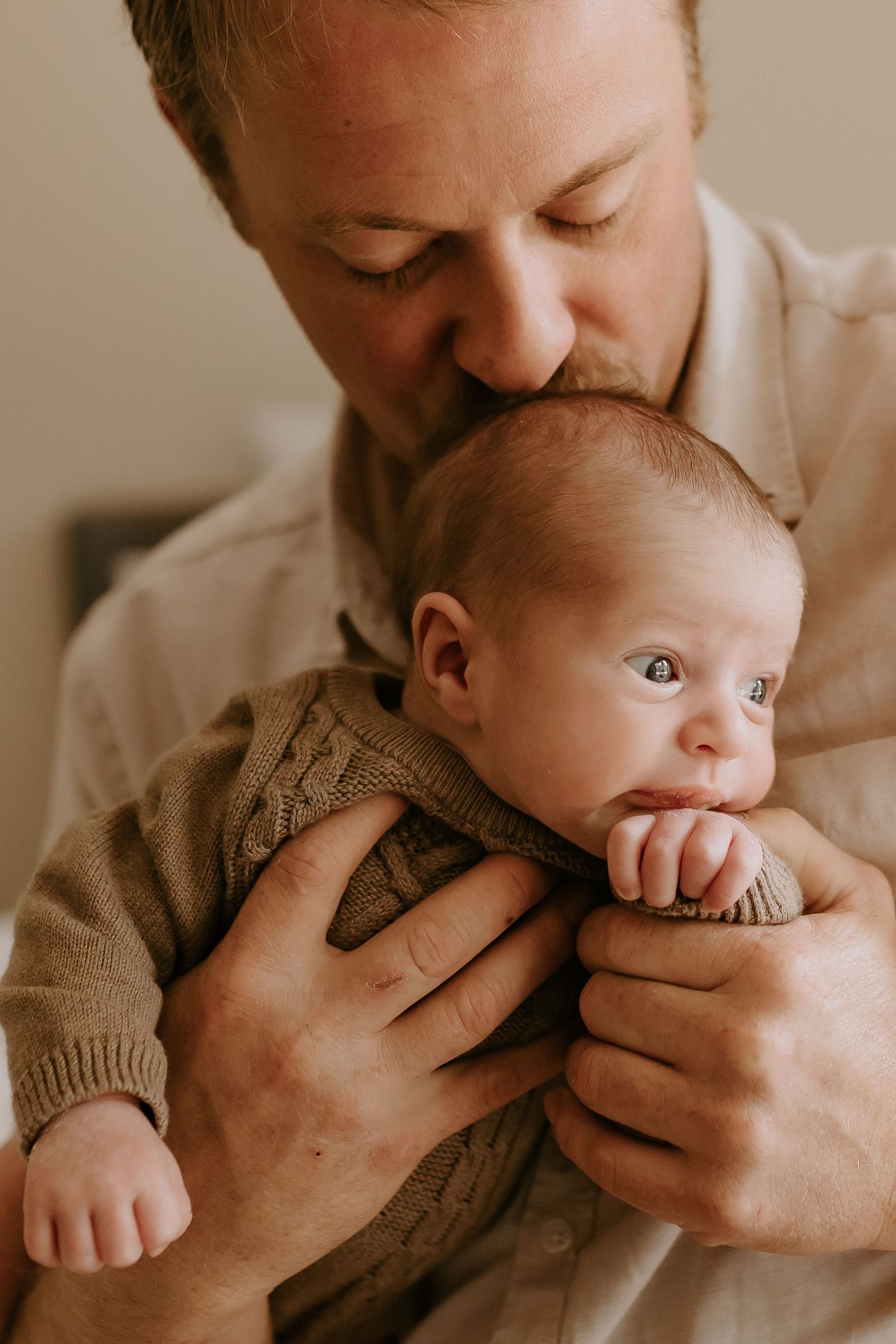 A tender moment between parent and baby in a knit sweater.