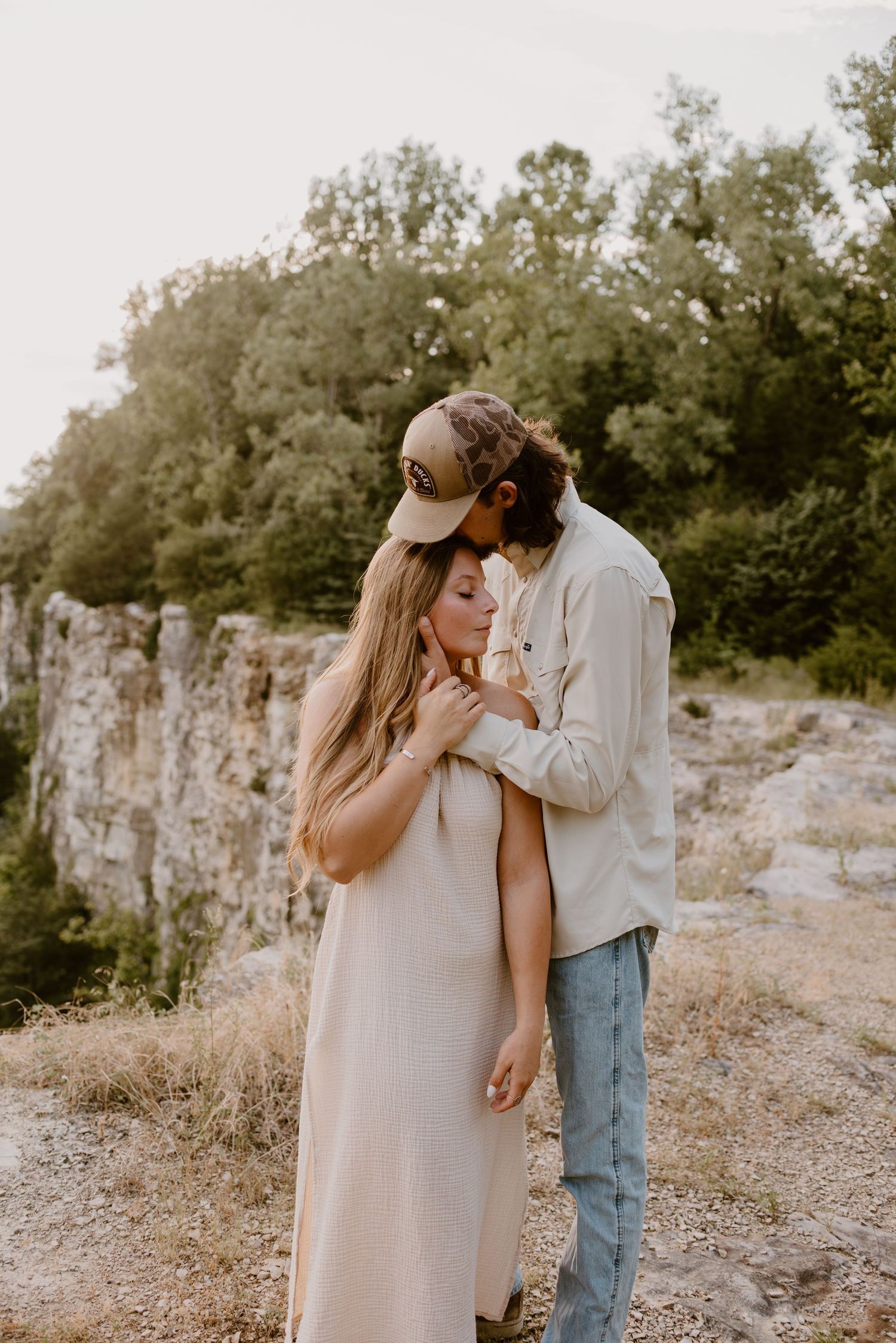 A romantic moment captured between a couple against a rocky cliff backdrop.