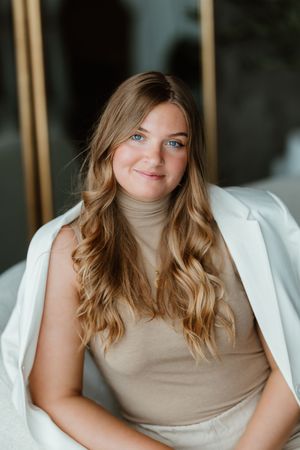 A series of four professional portrait photos showing someone in a beige top against a white background.