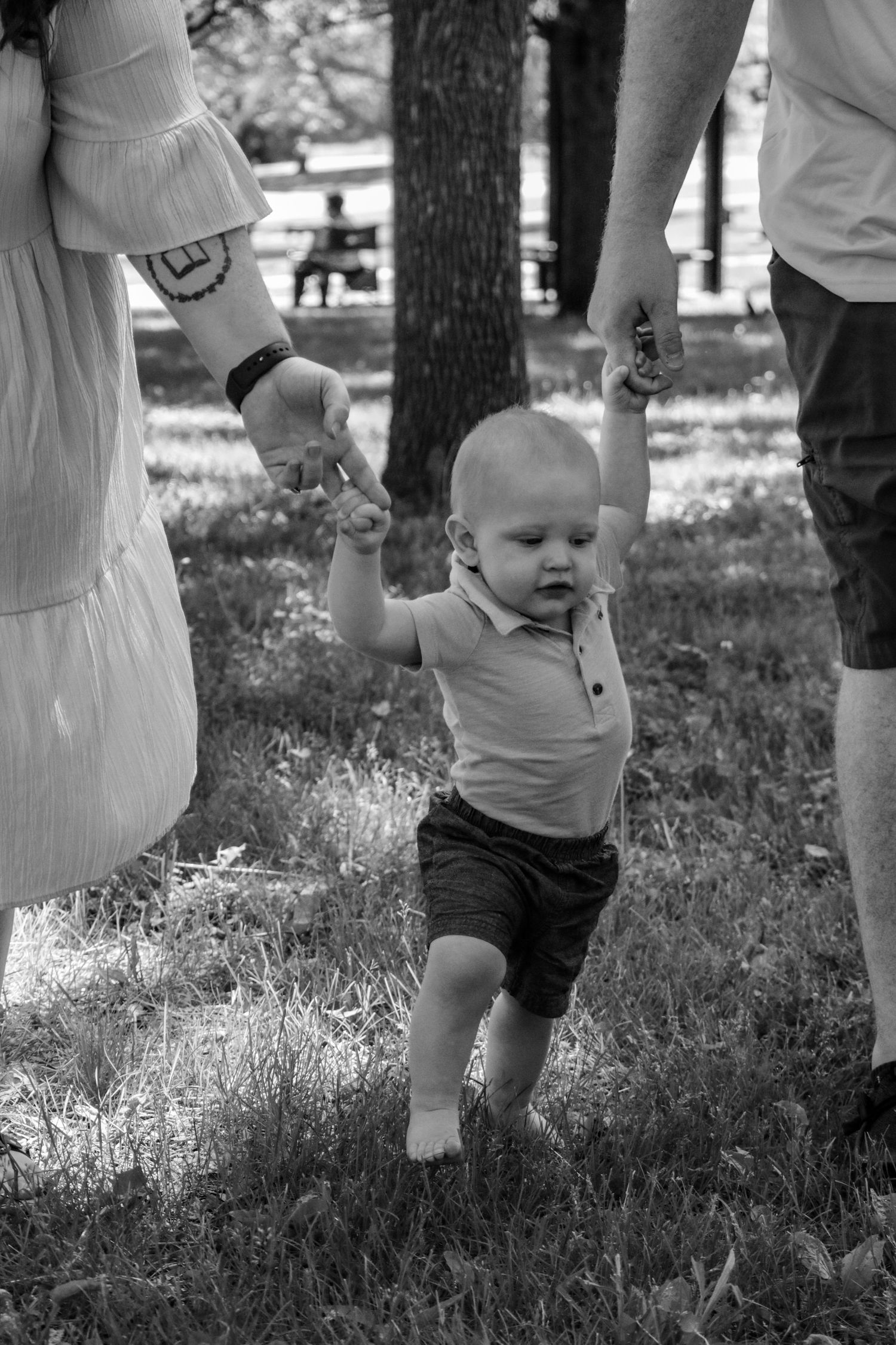 Baby walking holding hands with mom and dad