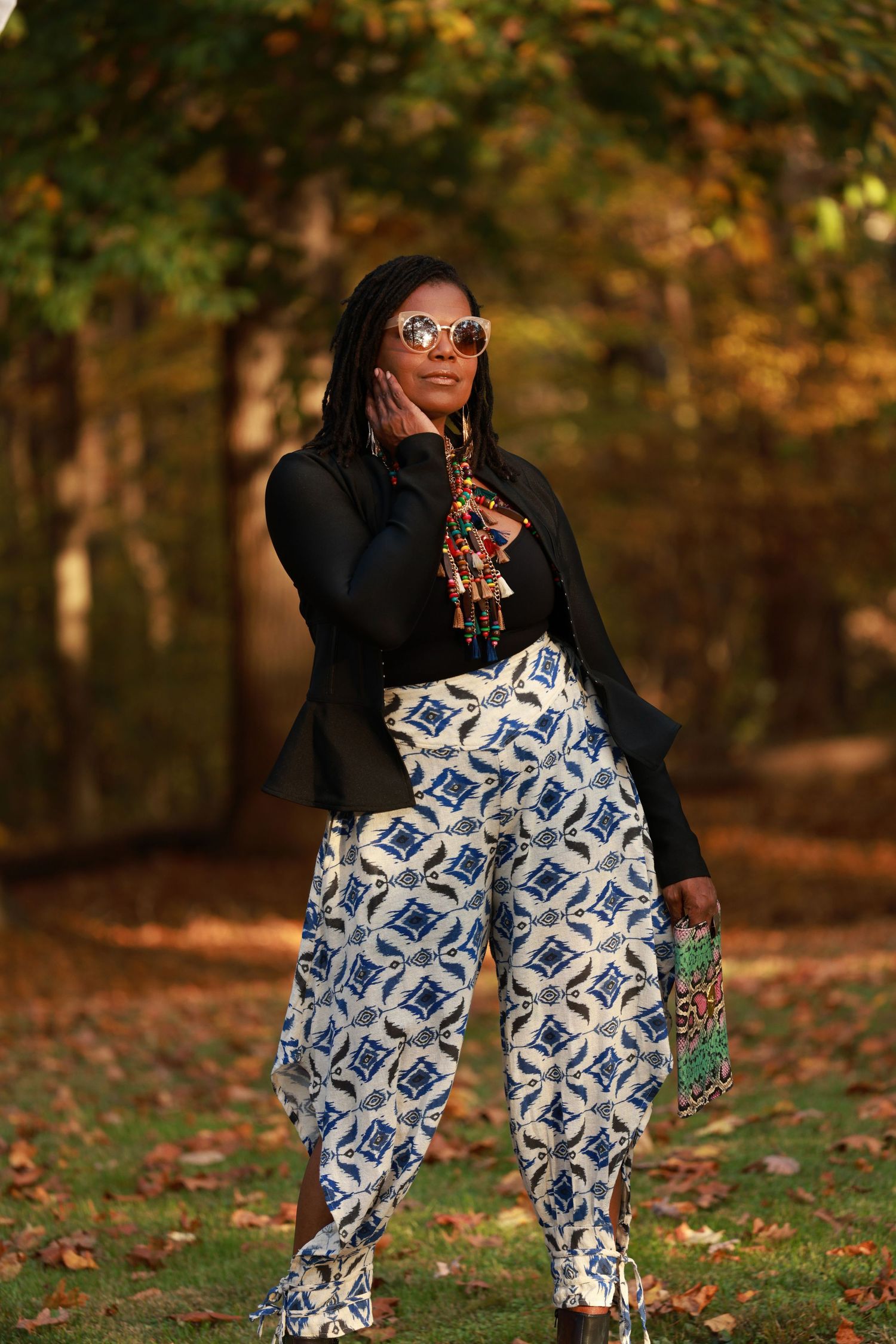 A Model wearing patterned pants and sunglasses poses in at our Upper Marlboro Studio during autumn taking advantage of the colorful leaves.