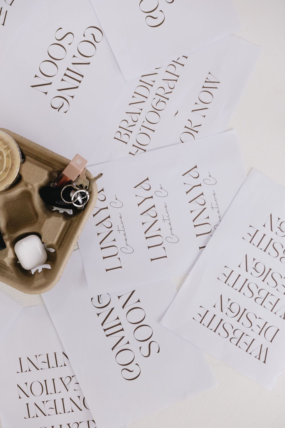Elegant white typography menu cards scattered on a table with black and white ink bottles in a beige holder.