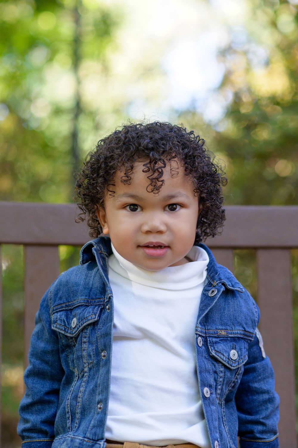 "Adorable little boy smiling brightly during a photoshoot, capturing pure joy and innocence in a heartwarming moment."