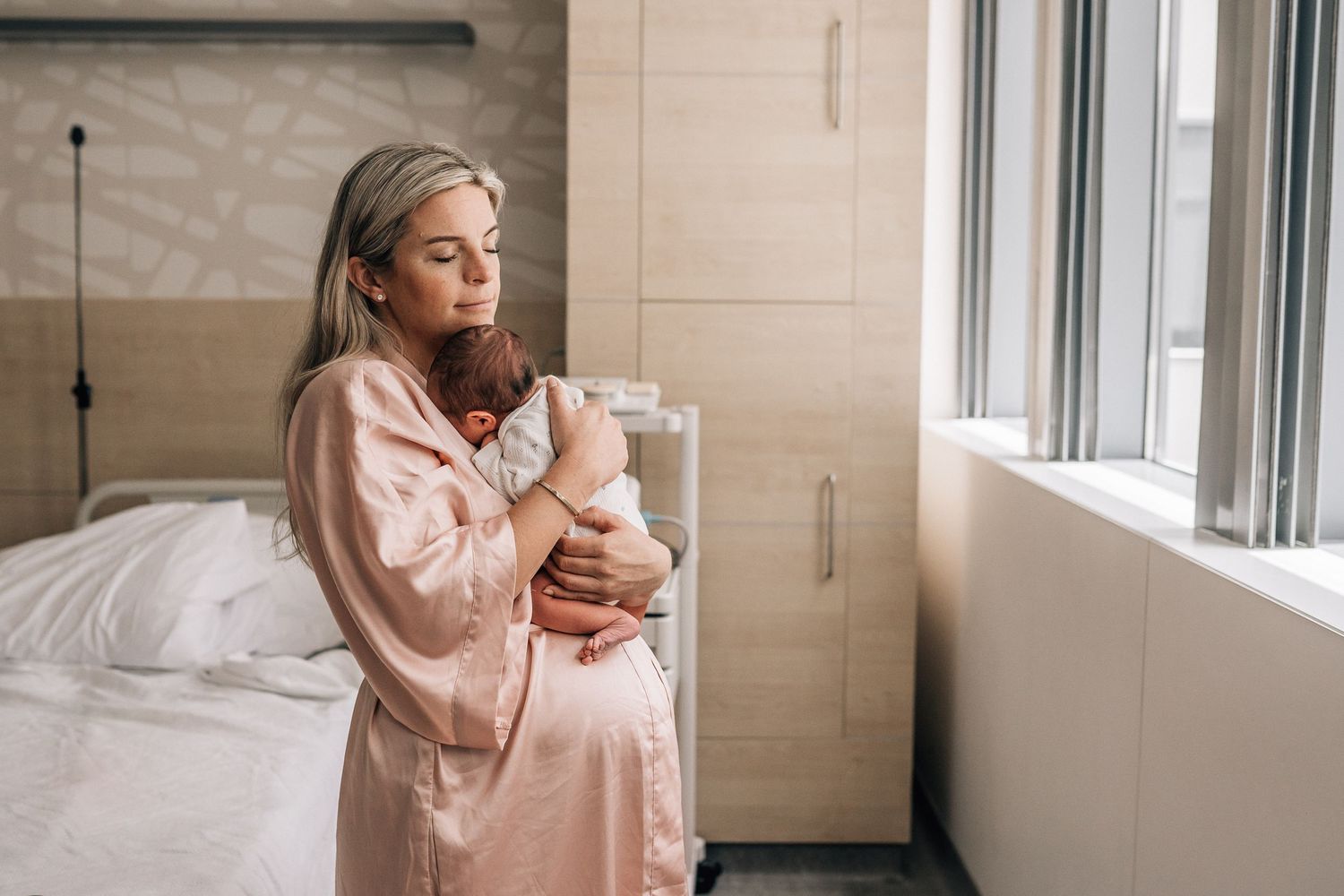 mom holding tenderly her newborn baby during a fresh 48 shoot in dubai hospital