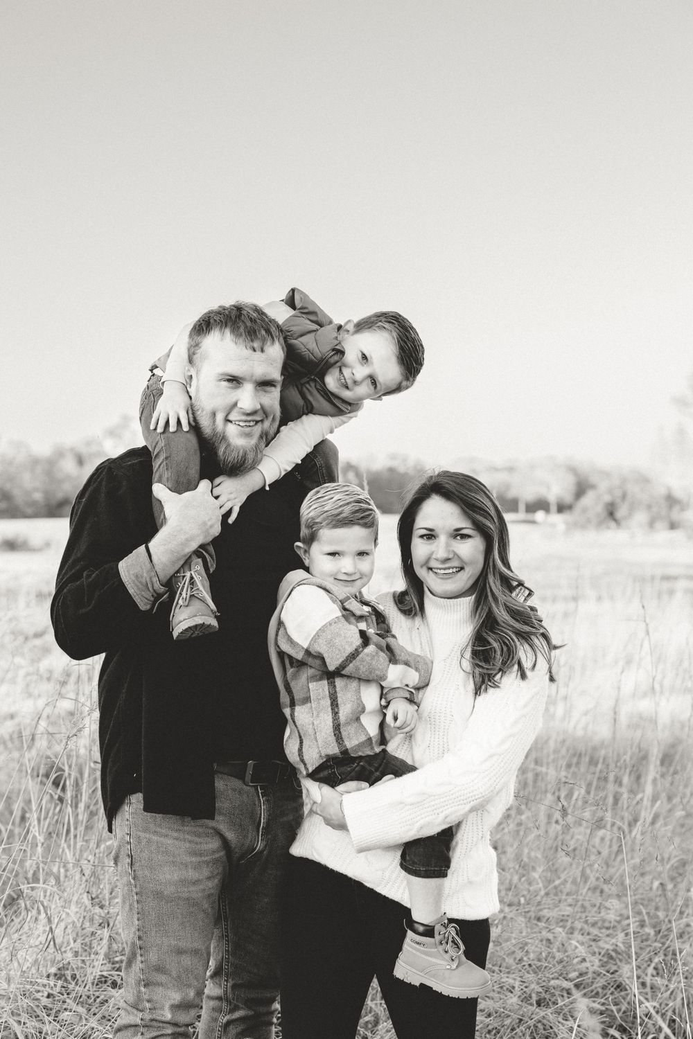 Black and white portrait of playful family enjoying outdoor photo session.