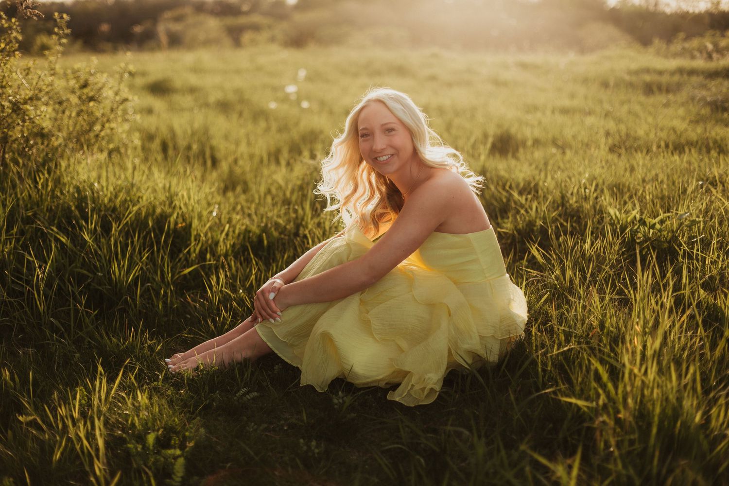 Golden hour senior portrait at Retzer Nature Center with a blonde graduate in a yellow dress among prairie grasses.