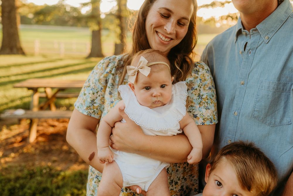 Baby girl being held by mom during family photos in Clarksville Tennessee. Photo by Disney Magic Photography Clarksville, TN.