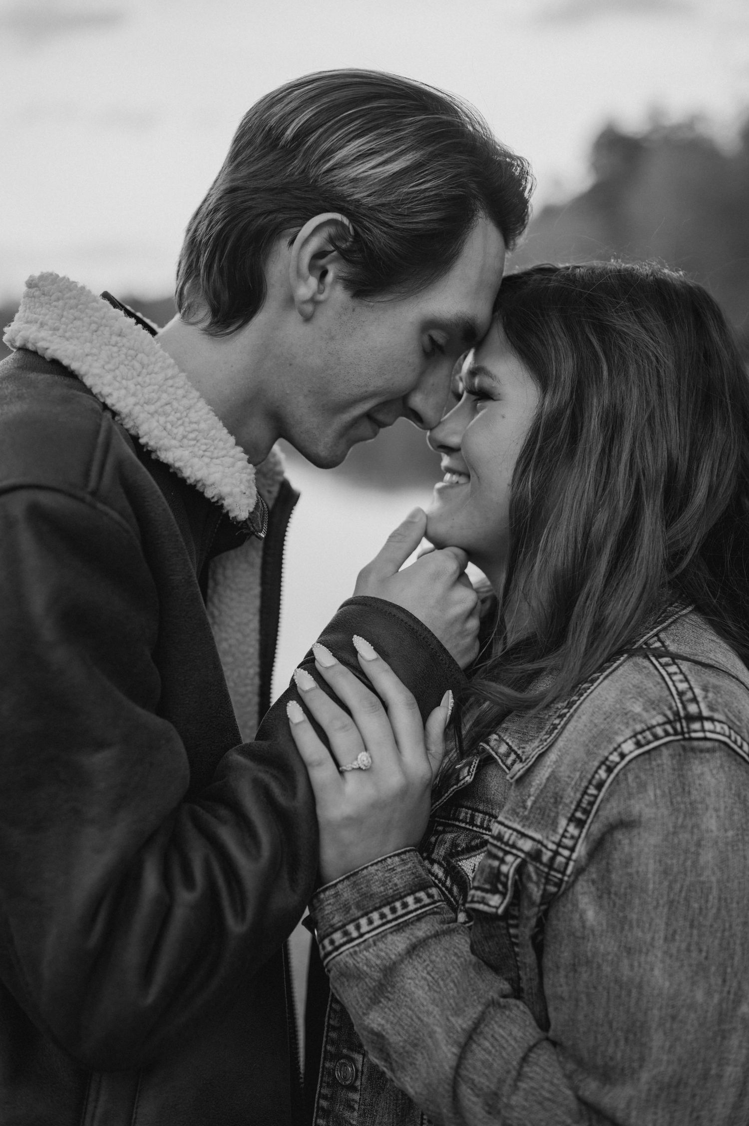 A romantic black and white photo series showing a couple in intimate close-up moments wearing casual outerwear.