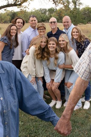 Sioux City, Iowa photographer. family  portrait taken outdoors in a field during autumn with adults and teenagers smiling at the camera.