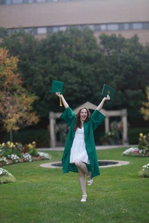 A sequence of photos showing a person in a green graduation gown doing cartwheels on a grassy lawn near a building.