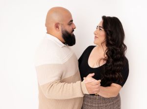Modern couples photoshoot showing affectionate poses in coordinated neutral outfits.