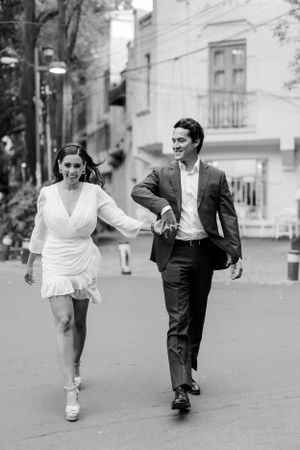 Black and white sequence of a playful couple running and dancing on a charming city street.