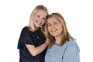 Studio portrait of two people sharing a close moment against white background.
