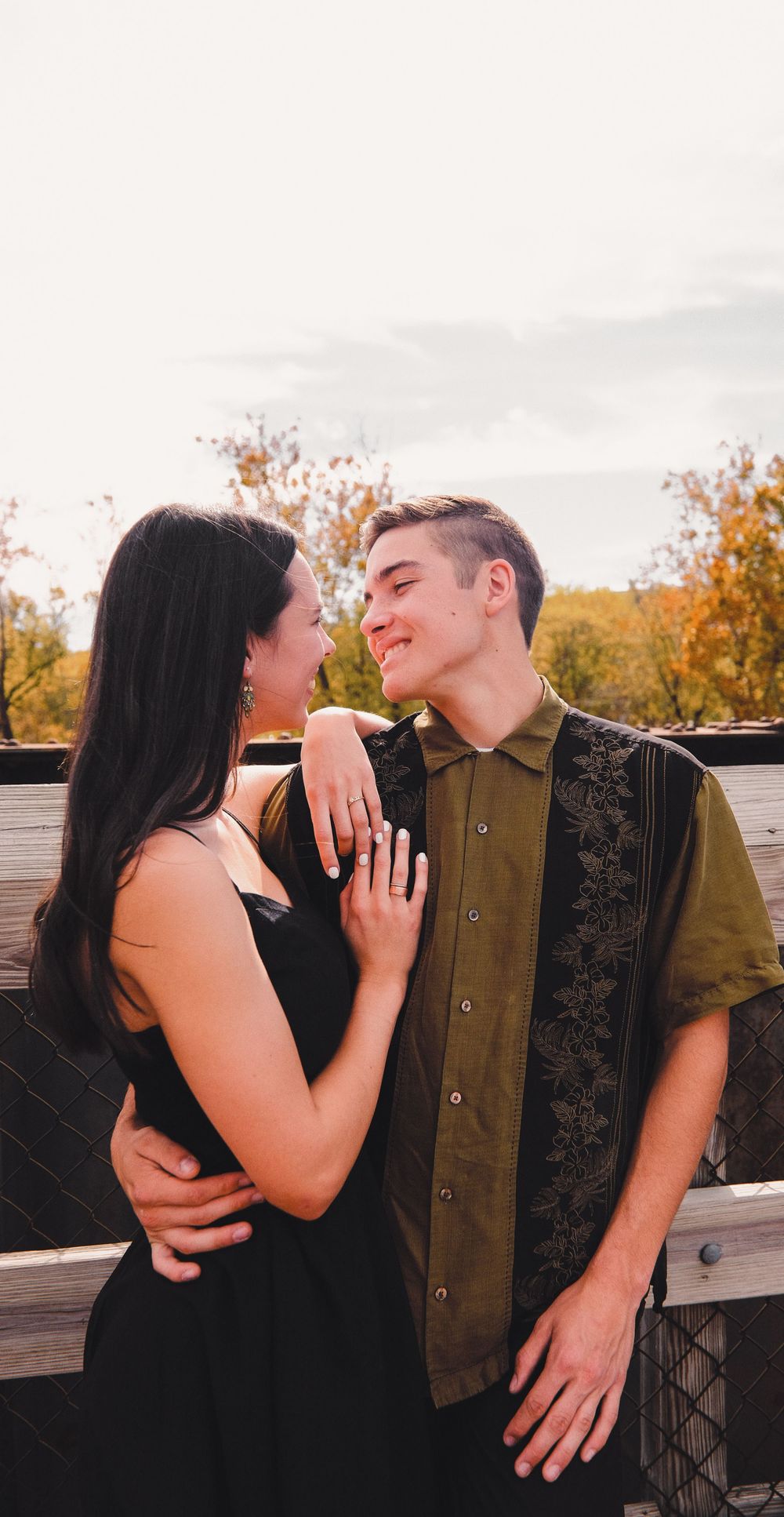 A romantic couple embraces and shares intimate moments in a series of sunset photos on a wooden deck.