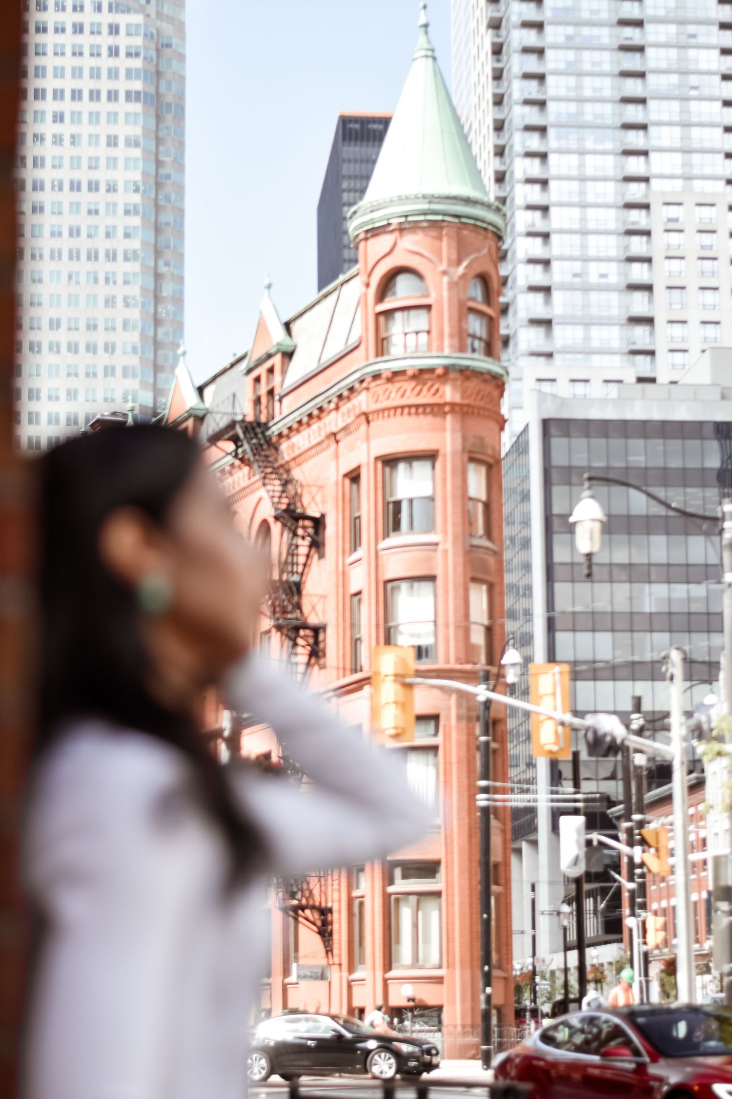 Woman standing near the iconic Gooderham Flatiron Building in downtown Toronto on a sunny day. Toronto GTA