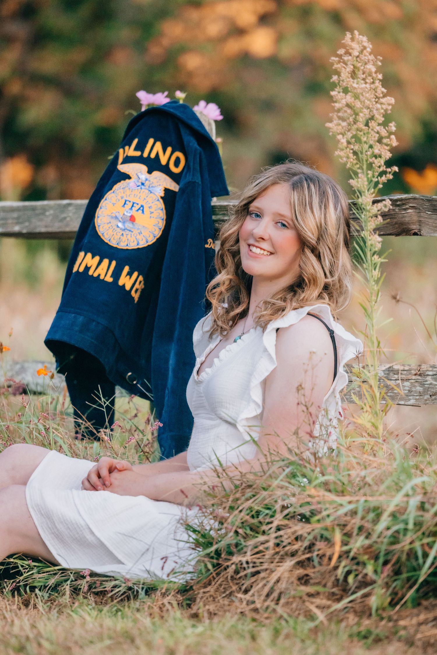 Senior sitting in grass posed with FFA jacket