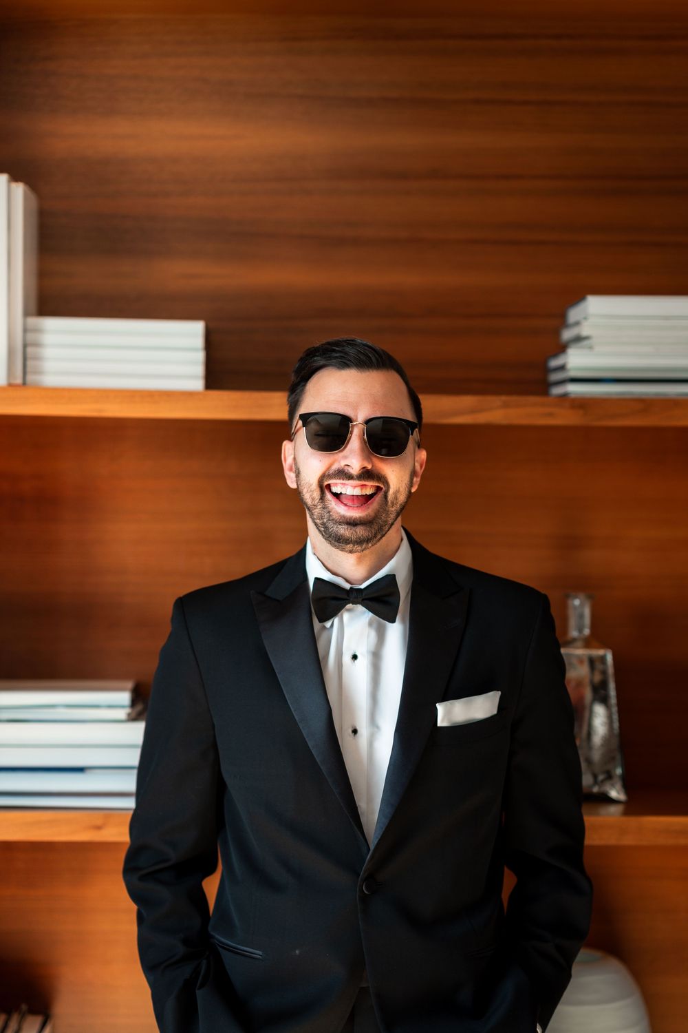 Progressive shots of someone in a tuxedo and bowtie against a wooden paneled wall.