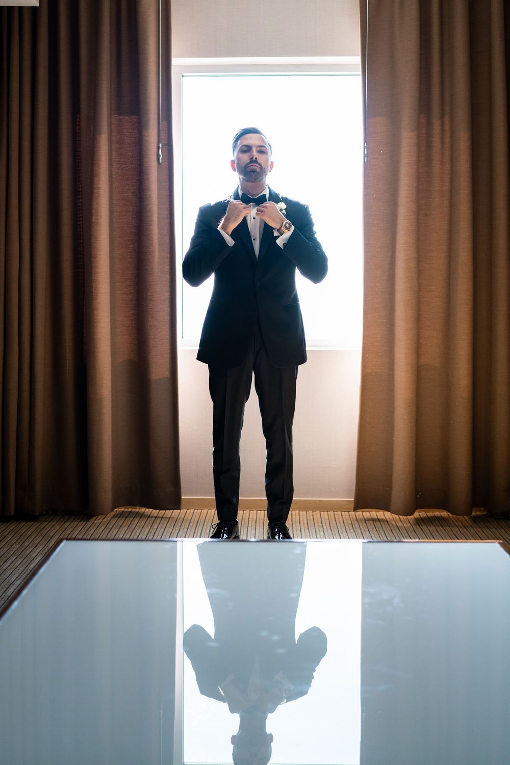 Series of reflective shots showing a person in formal wear against curtained windows.