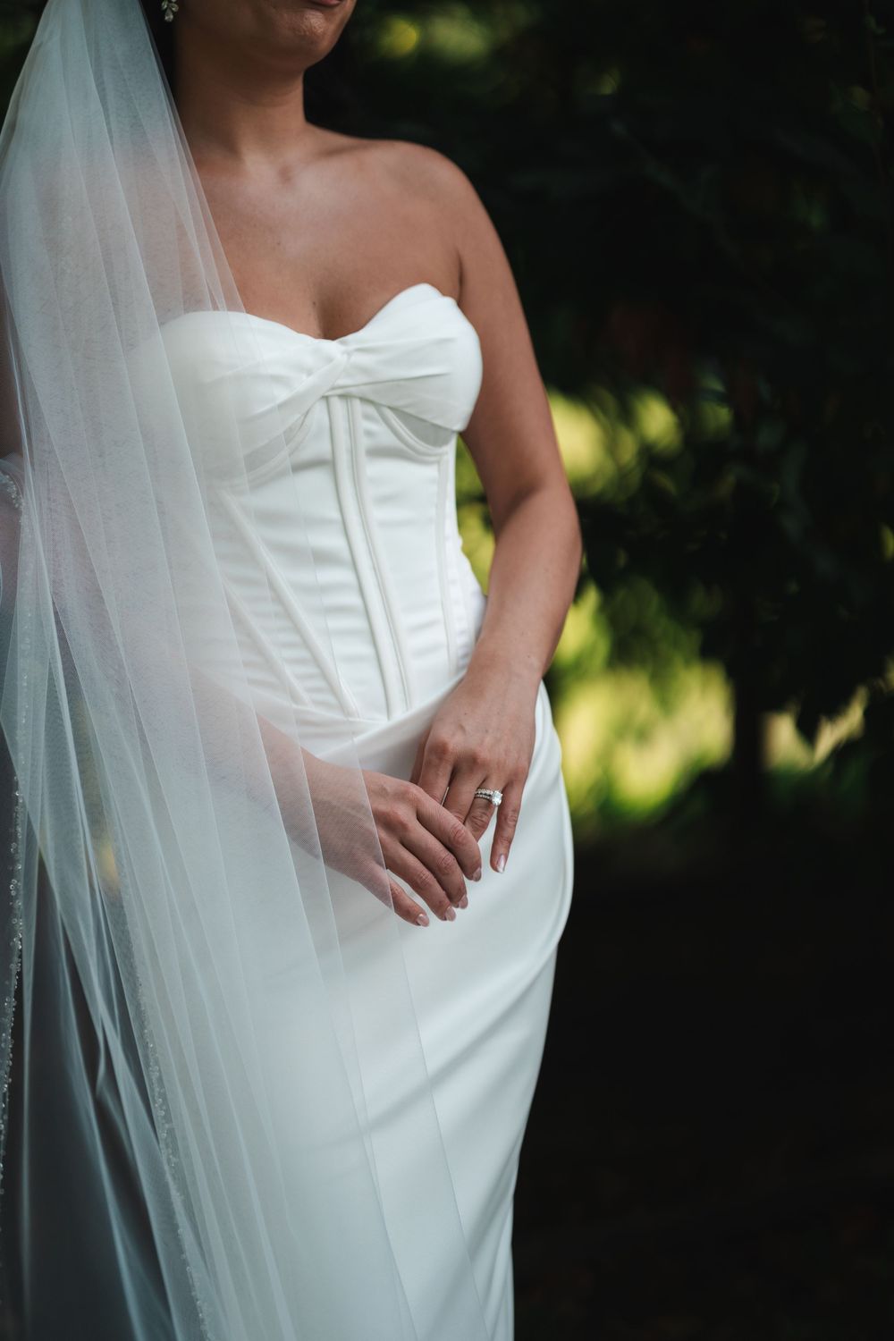 Close-up detail shots of a white wedding dress with delicate fabric and elegant styling in natural lighting.