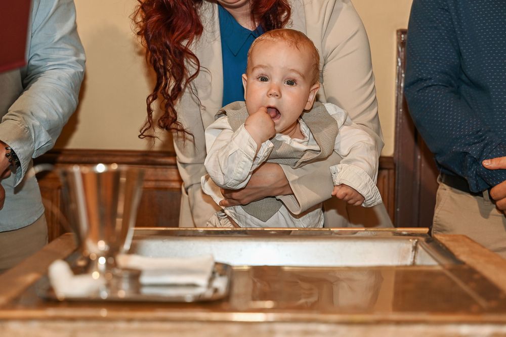 A sequence of photos showing someone being fed a small piece of food at a wooden dining table.