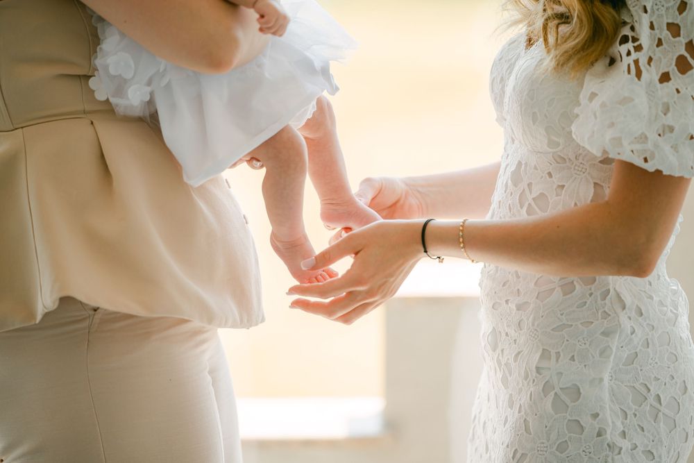 Couple share an intimate moment in formal attire against a bright window during their wedding celebration.