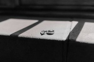 Wedding rings casting dramatic shadows in black and white photography.